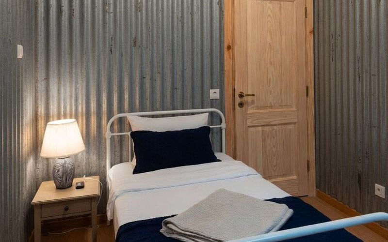 Optional bedroom module inside a Micro-Hangar — a cosy sleeping area with corrugated metal walls